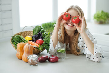 Beautiful young woman eating vegetables in the kitchen. Healthy food. Vegan salad. Diet. Diet...