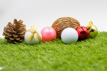 Golf ball with Christmas ornament on green grass