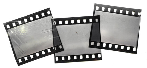 three scratched 35mm dia film snips overlapping each other on white background.