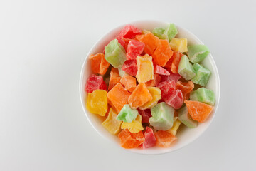 Candied fruits in a white bowl on a white background