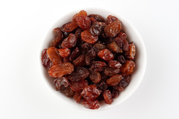White bowl with raisins on a white background and space for text, top view.