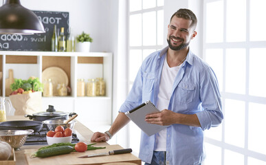 Smiling and confident chef standing in large kitchen