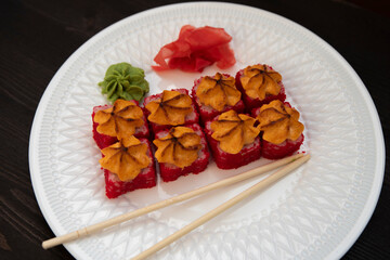 Set of eight sushi rolls on a white plate with salmon, eel, tuna, avocado, king prawn, cream cheese, tobiko caviar, Chuka. The sushi menu. Japanese cuisine. Top view of assorted sushi.