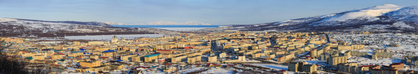 Fototapeta na wymiar Panorama of Magadan city. Top view of a large northern city. Beautiful cityscape with many buildings. In the distance are mountains and a sea bay. Magadan, Siberia, Far East of Russia. Panoramic photo