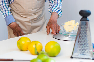 Hands of an old man weighing ingredients