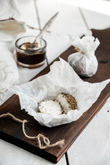 Cheese belper knolle with black pepper and spices. Cut in half. On a textile napkin. Gray wooden background.