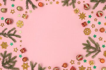Fototapeta na wymiar Round frame made of Christmas decorations pattern on a pink pastel background. Festive concept with copy space.