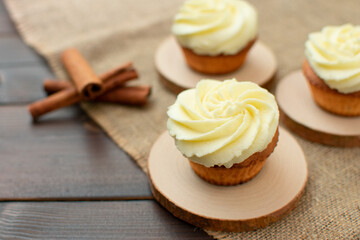 Cupcakes with swirling glaze on wooden supplies and burlap.