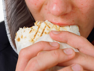 portrait pimply teenager eating fast food shawarma