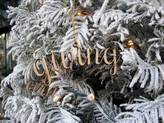 Word Giving wooden cutout decoration on white Christmas tree