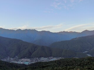 Aerial view panoramic landscape of mountains at sunset on the background of blue sky. Beautiful sunset landscape in the mountains