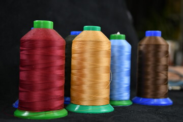 Set of colored threads for sewing on coils. Pile of big colorful spools of thread. Colored thread spools of thread large class, textiles, background