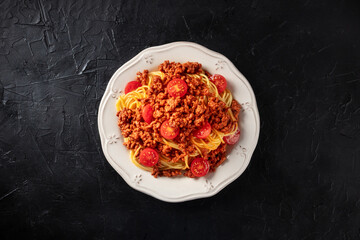 Spaghetti bolognese pasta, overhead shot on a black background