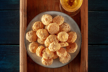 Amaretti, traditional Italian almond cookies, with a glass of Amaretto liqueur, top shot on a dark blue wooden background
