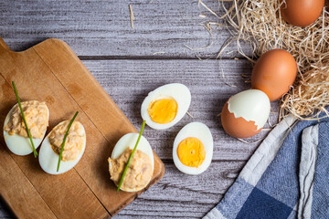 Variedad de huevos, rellenos y duros sobre un fondo rústico gris claro y elegante