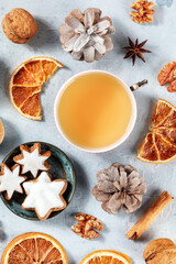 Winter holidays flat lay with a cup of tea, cinnamon cookies and various organic decor, sustainable Christmas concept, overhead view