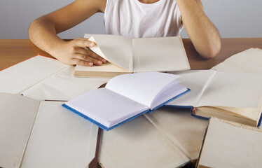 School child at the table with books.