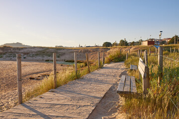 Sandy walkway and wooden benches at Playa America in Galicia, Spain