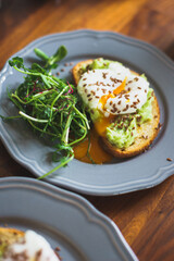 Full healthy morning breakfast: toast with guacamole, avocado, poached egg and flaxseed.