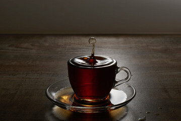 A Cup of freshly brewed black tea, warm soft light, dark background.