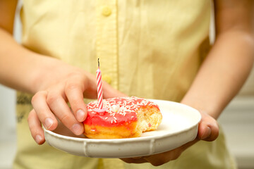 Congratulations with a cake on a plate in the hands of a teenager