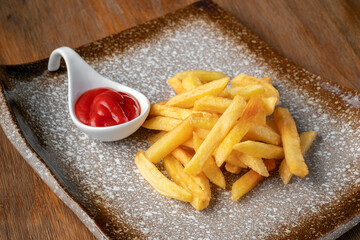 Portion French Fries on a plate with ketchup