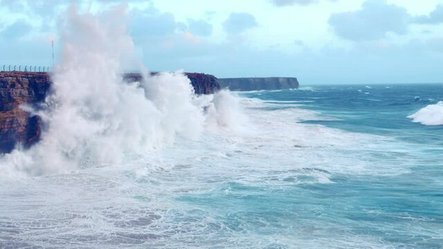 Slow motion, waves crashing against cliff with huge splashes, Sagres in Algarve of Portugal