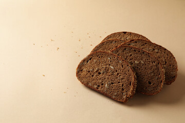 Fresh baked rye bread slices on beige background