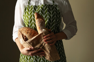 Woman in apron hold fresh baked bread