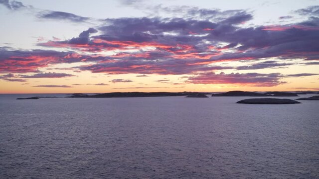 Swedish Bohuslan west coast sunset view. Open ocean with small granite rocky island at horizon