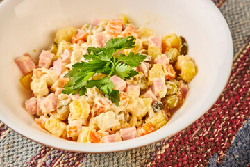 bowl of traditional russian salad on wooden table close up