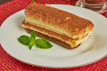 Piece of sponge cake and a cup of hot coffee on table