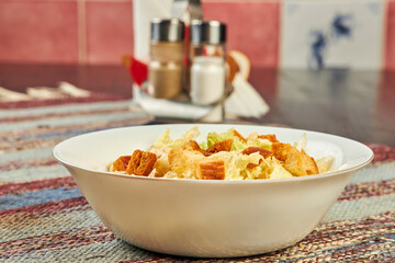 Closeup of fresh salad with croutons on table in cafe