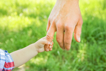 the parent holding the child's hand with a happy background