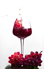 Red wine splashing in the wine glass against the white background