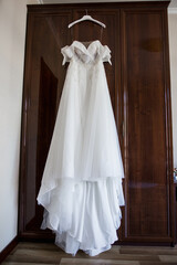 bride's wedding dress hanging on the wardrobe