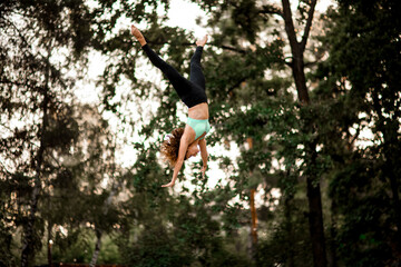 attractive woman jumping masterfully and performs trick upside down in the air