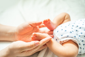 Mother holding baby feet in both hands