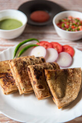 Pieces of popular Indian breakfast item alu paratha in a plate