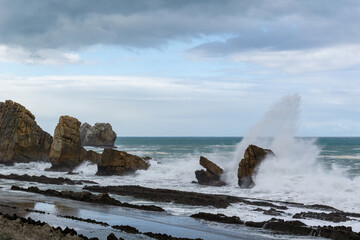 rocky and wild coast with stormy waves hitting the shore