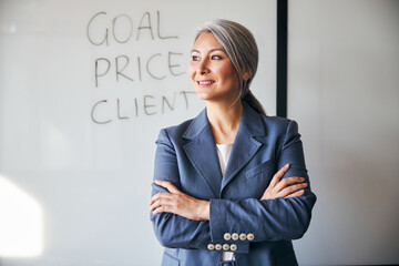 Beautiful businesswoman standing by whiteboard in office