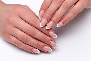 Wedding french sharp white manicure with crystals on long sharp nails close-up on a white background