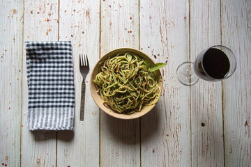 Italian delicacy pasta in pesto sauce and drink on a background with use of selective focus.