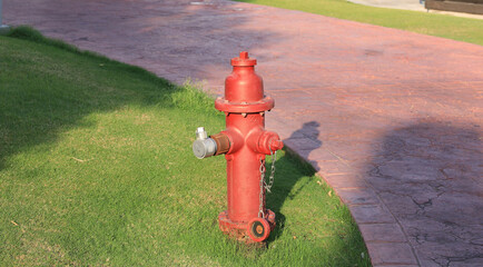 Fototapeta na wymiar red water hydrant on a green lawn