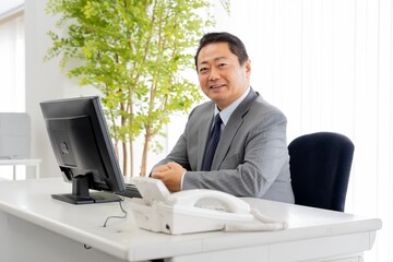 Naklejka premium 仕事をするアジア人50代男性