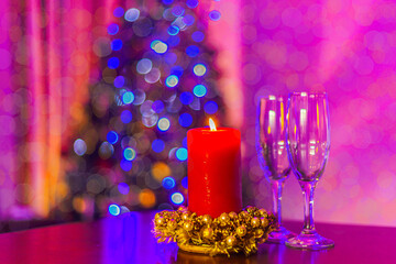 Two champagne glasses and candle over christmas eve  bokeh background. New year and christmas luxury party celebration. 