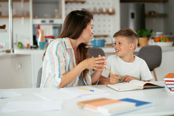 Mother helping her son with homework at home. Little boy learning at home..