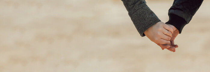 long format banner , hands of different people held together close-up. on one hand is gold wedding...
