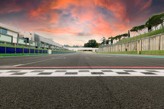 Motor sport circuit asphalt track starting and finish line checkered sign front view scenic sunset cloudy sky