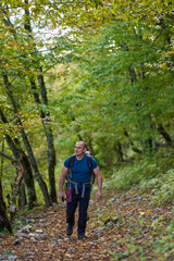 Naklejka na ściany i meble Man hiking into the forest